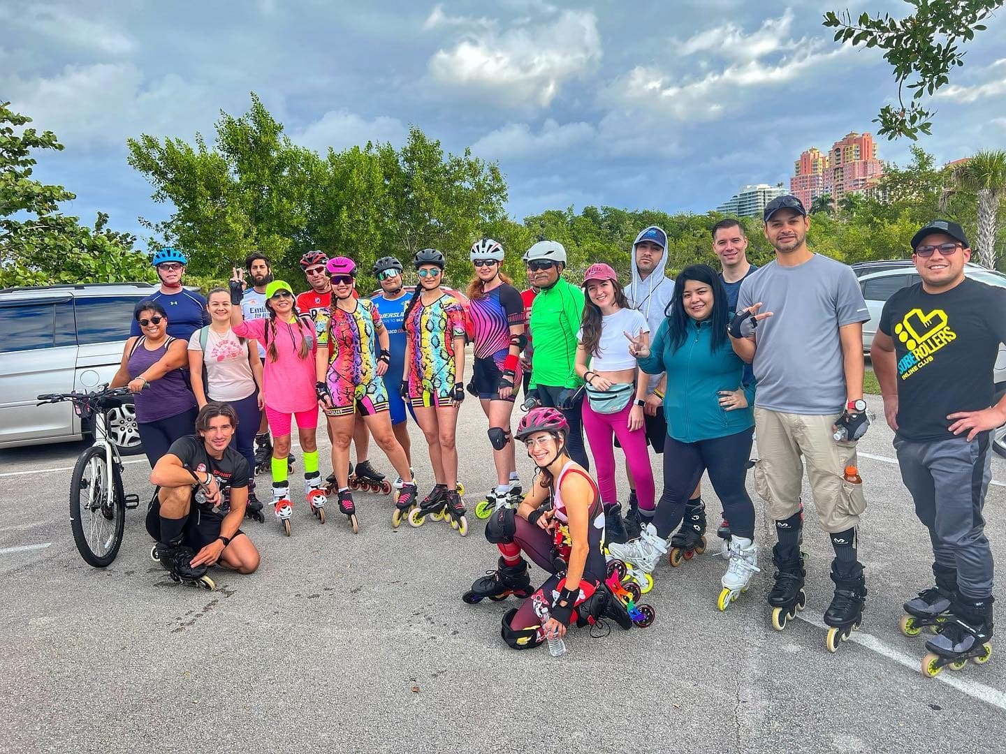 A group of skaters posing in a parking lot by the trees after a day skate