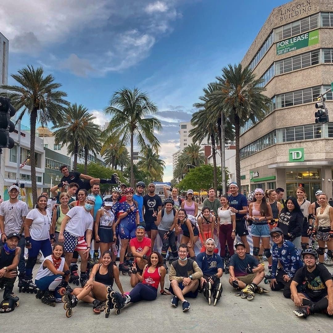 Skaters gathered on Lincoln Road under palm trees on a sunny day